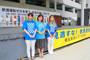 2019年8月飲酒運転撲滅大会ステージ前の女性３人の画像