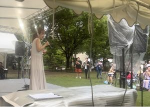 舞台上にマイクを持つ女性