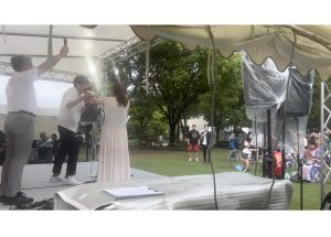 舞台上で男性と女性 観客と一緒に乾杯