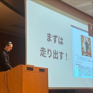 プロジェクターで発表する男性