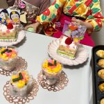 こども２人の前にケーキとバラ寿司