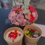 カップに入ったデザートと活けられた花